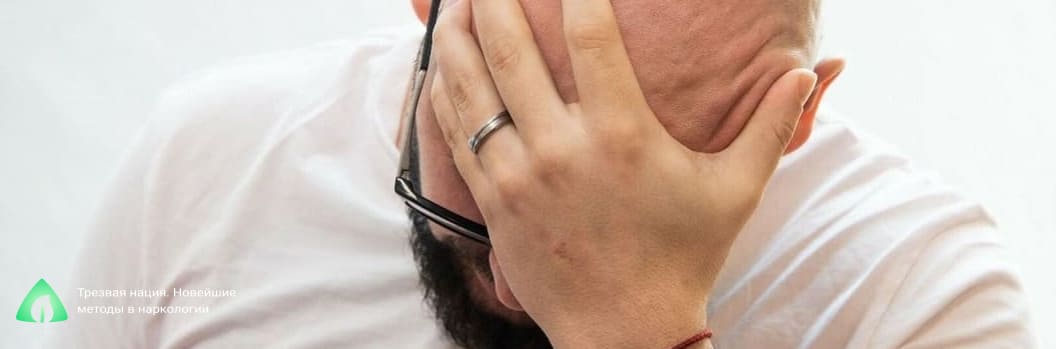 Мужчина держится рукой за голову